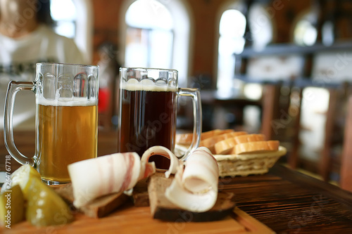 Photography two beer mugs in a Czech beer restaurant / light and dark beer in large mugs tra