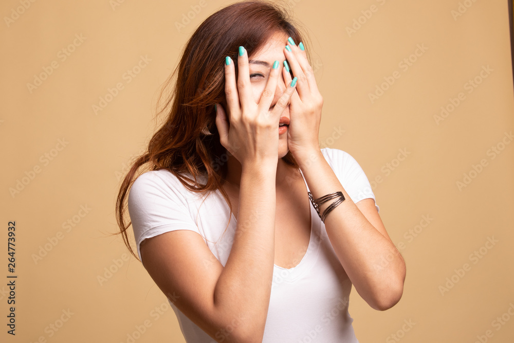 Beautiful young Asian woman peeking through fingers. Beautiful young Asian woman peeking through fingers.