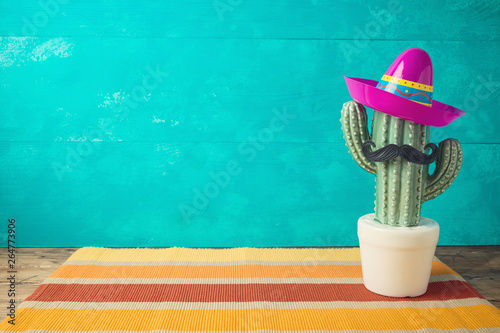 Cinco de Mayo holiday background with Mexican cactus and  party sombrero hat on wooden table photo