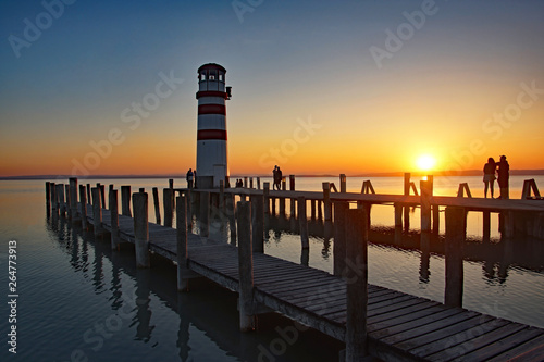 Sonnenuntergang mit Leuchtturm und Steglandschaft am Neusiedler See im Burgenland