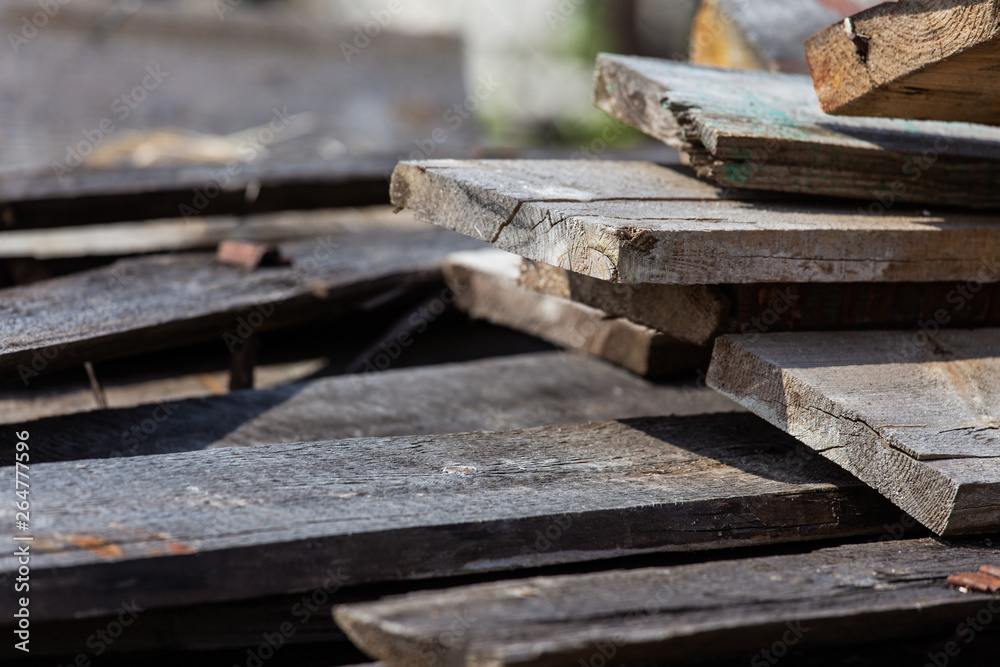 A stack of old wooden planks that lie on the ground