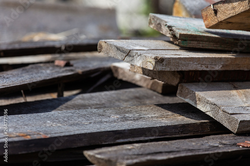 A stack of old wooden planks that lie on the ground