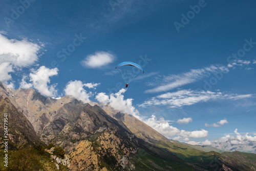 Paragliding in mountains. Extreme sport. Flight on paraglider over mountains of Caucasus