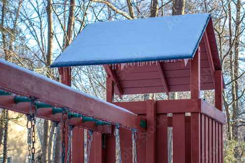 frozen swingset with icicles and snow in the winter photo