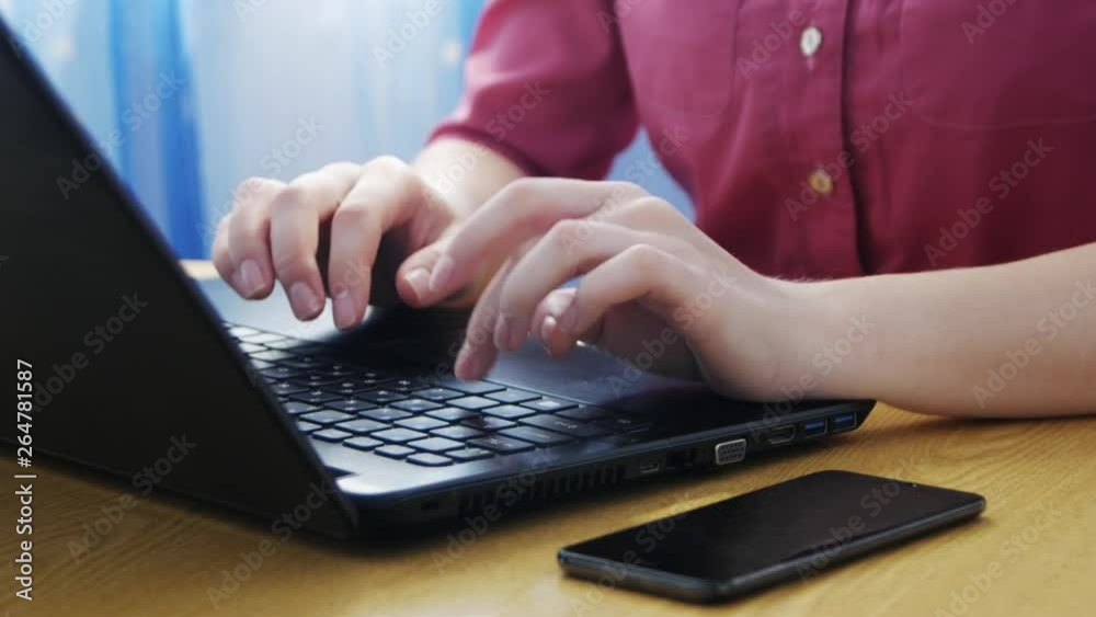The girl stretches her hands before typing on a laptop. Woman typing on laptop keyboard. Close up woman hands writing on laptop computer keyboard. Concept working at home, freelance. The girl stretches her hands before typing on a laptop. Woman typing on laptop keyboard. Close up woman hands writing on laptop computer keyboard. Concept working at home, freelance.