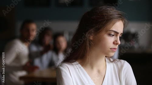 Sad offended teen ignoring friends apologizing for bad joke