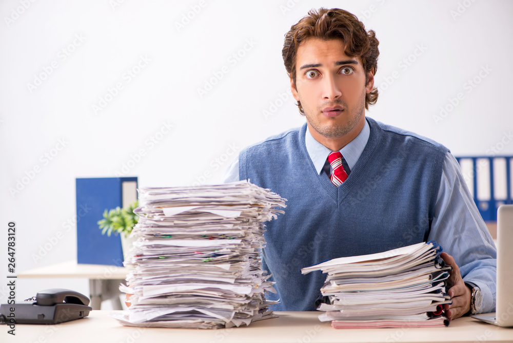 Young handsome employee unhappy with excessive work Young handsome employee unhappy with excessive work
