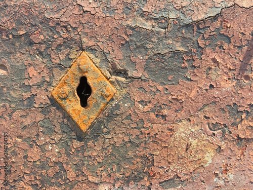 Old weathered chappy door with rusty keyhole