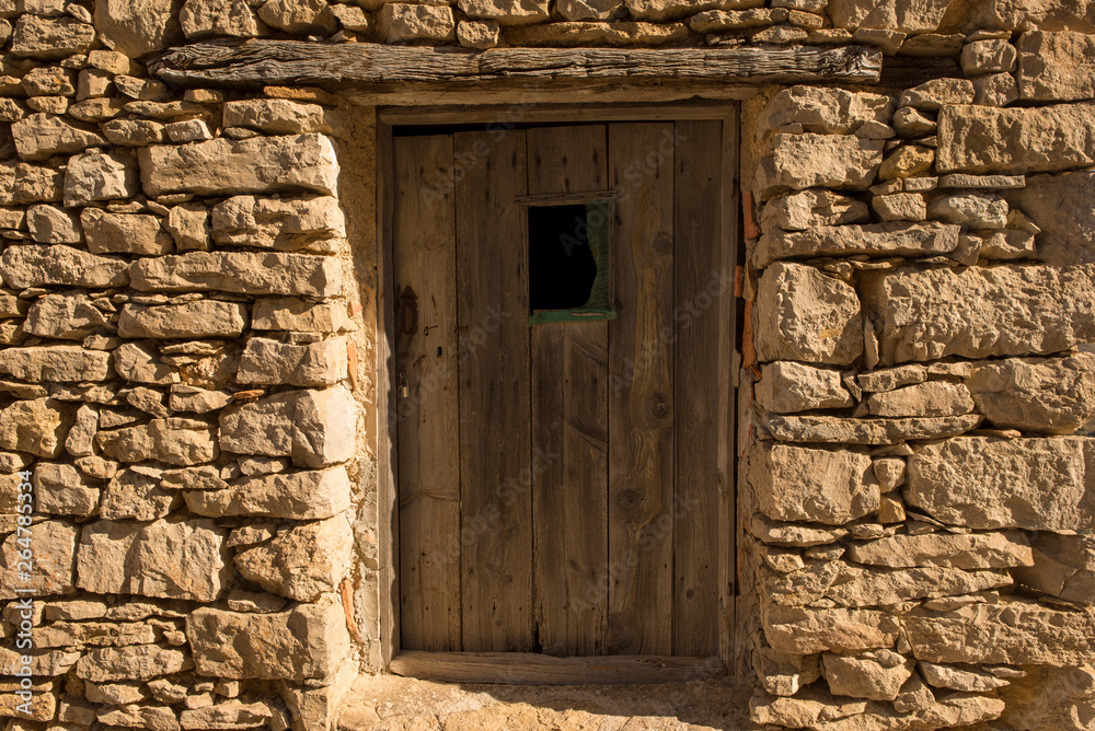 Fototapeta premium A wooden door in a stone house