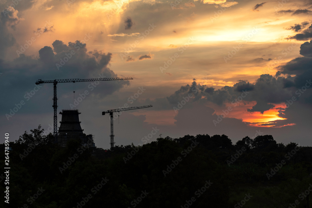 Beautiful Silhouette crane under construction building at sunset time