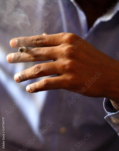 Closeup of Indian man  a smoker  hand holding cigarette