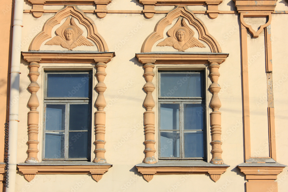 Obraz premium Two windows on beige building wall of classical house. Architecture detail of ornamental historic facade exterior