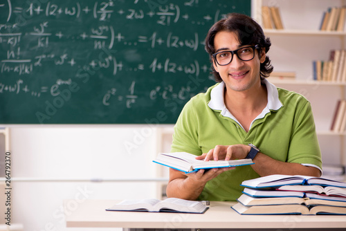 Handsome student in front of chalkboard with formulas 