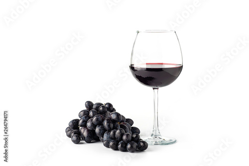 Red wine in a glass with grapes on a white background