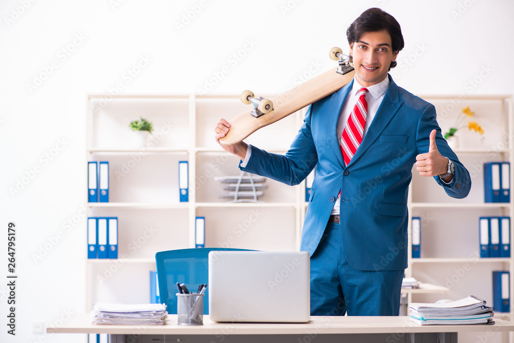 Young handsome businessman with longboard in the office Young handsome businessman with longboard in the office
