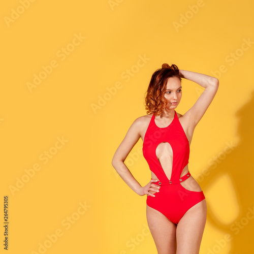 slim sexy girl with a narrow waist on a yellow background