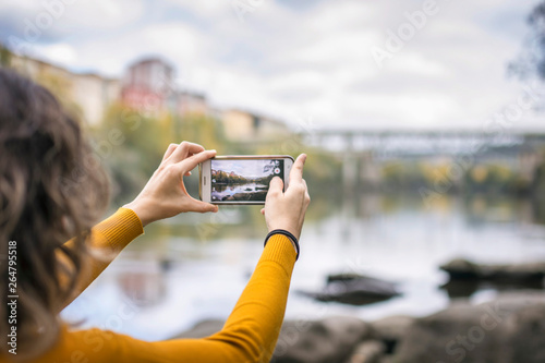 woman taking a picture of a cityscape with her smartphone © Fernando