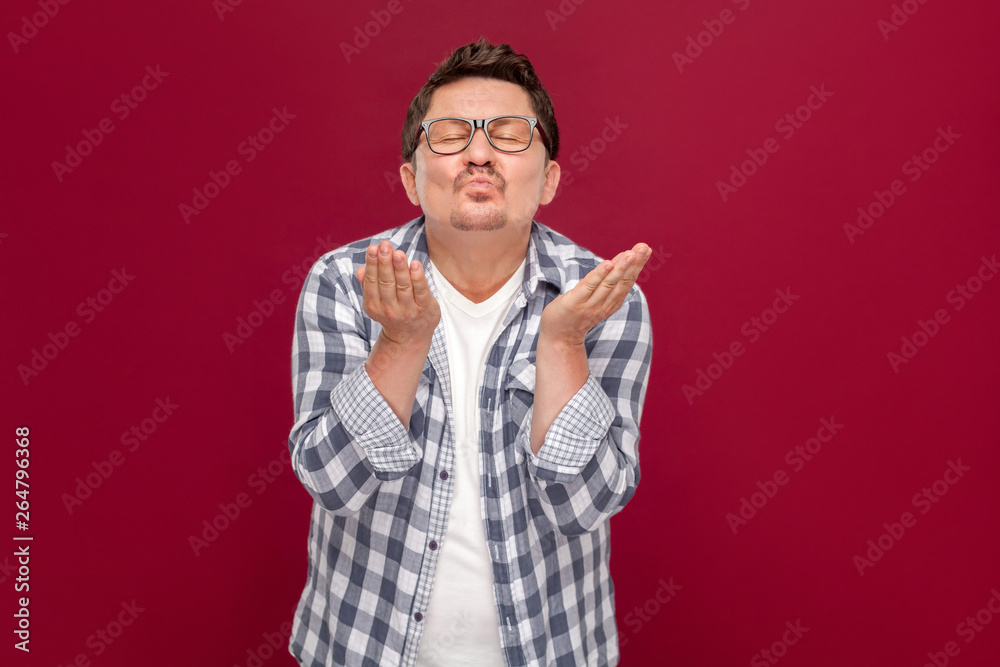 Portrait of happy in love handsome middle aged business man in casual checkered shirt, eyeglasses standing, closed eyes and sending kiss at camera. Portrait of happy in love handsome middle aged business man in casual checkered shirt, eyeglasses standing, closed eyes and sending kiss at camera.