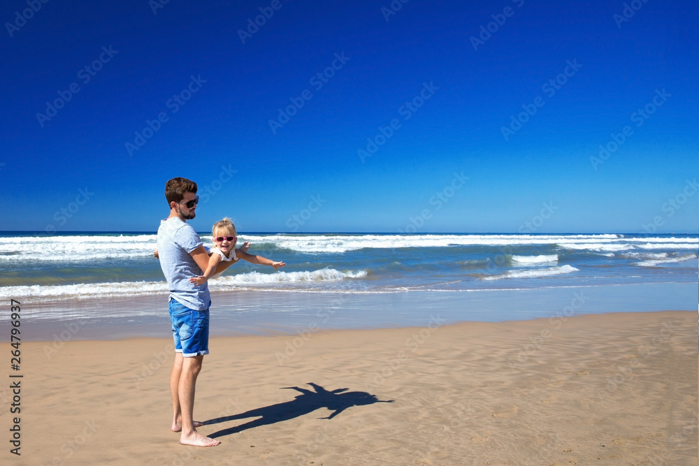 Father and daughter have fun on the seashore.