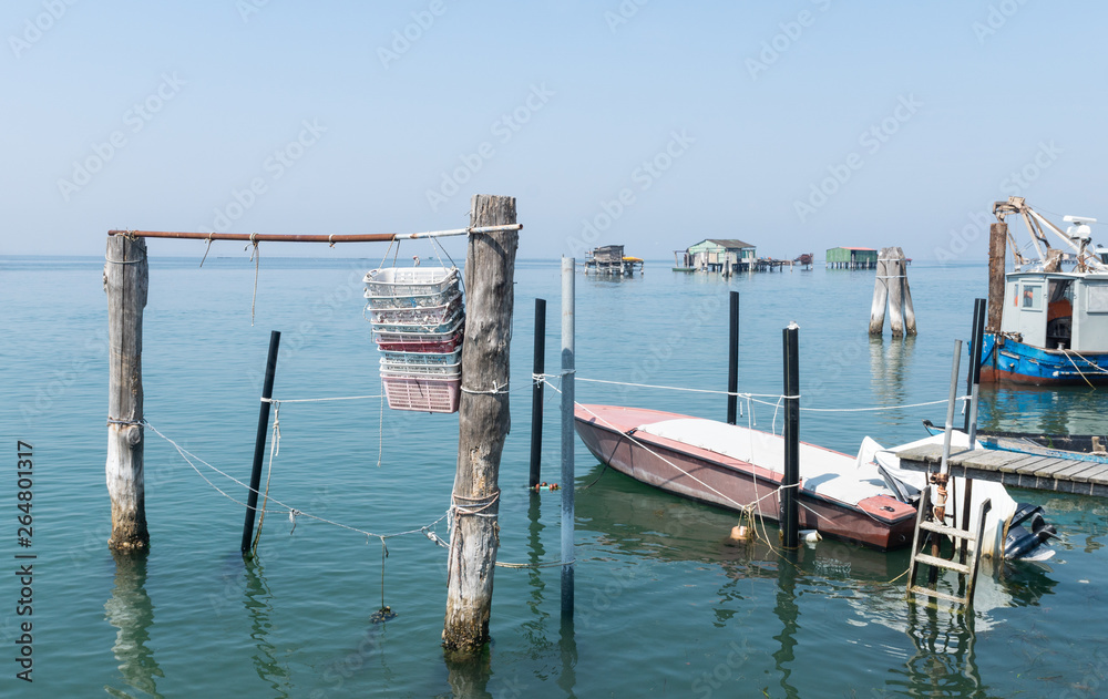 Plastikkörbe und Fischerboot auf Pellestrina