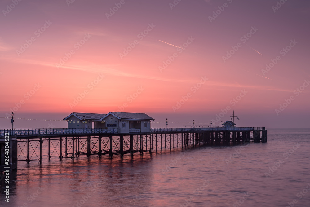 Penarth Pier, on the south Wales coast, near Cardiff, at sunrise. The sky is red and orange, and the sea is smooth