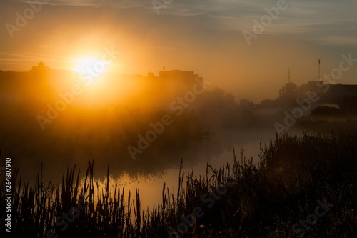 orange hour after foggy sunrise near river