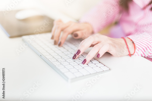 Woman fingers typing on desktop computer keyboard.