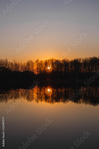 Sunset on the lake. There is a forest in the distance © WoodHunt