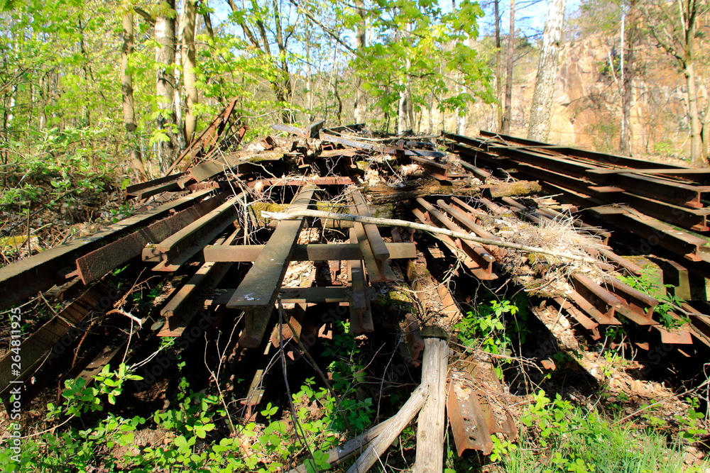 Lost Place, alte Schienen in einem Steinbruch wurden auf einen Haufen gestapelt Lost Place, alte Schienen in einem Steinbruch wurden auf einen Haufen gestapelt