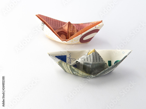 Two origami boats made of five and ten euro notes isolated on white background
