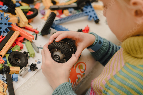 erector set of colored gears. child collects a car photo