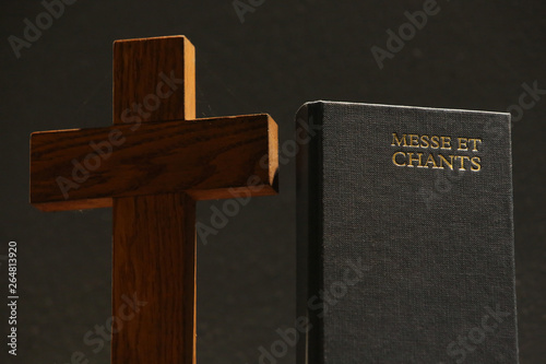 Croix en bois et livre de messe et chants. / Wooden cross and book of mass and songs.