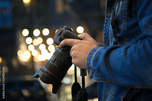 Εκτύπωση καμβά photographer with a camera on the background of evening street lights