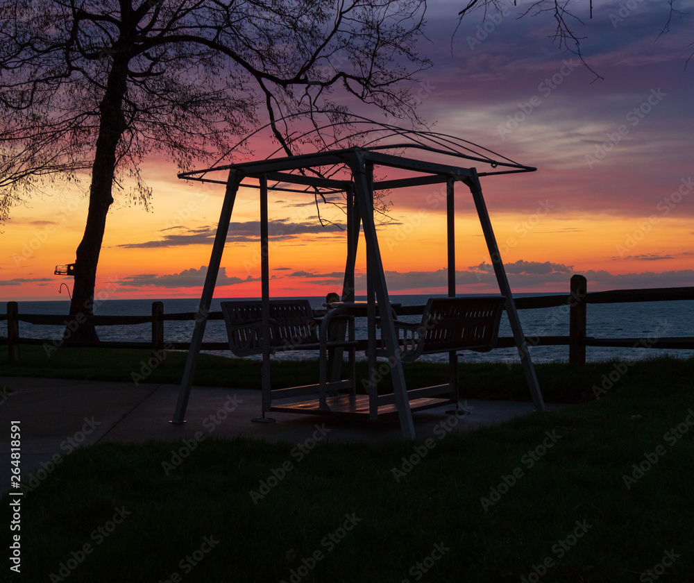 Fototapeta premium Park swinging bench with colorful dramatic sky 