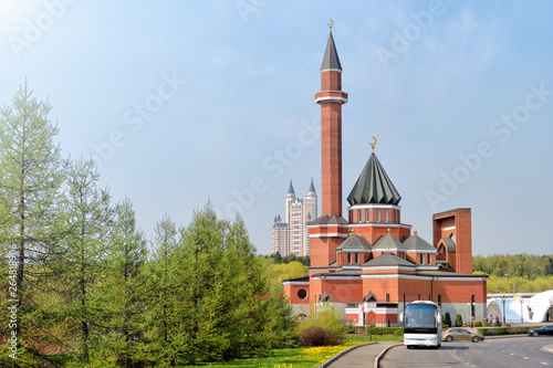 mosque modern street architecture in moscow city russia skyline side view of islam religion minaret building with spring time green park forest landscape scenic cityscape landmark blue sky background photo