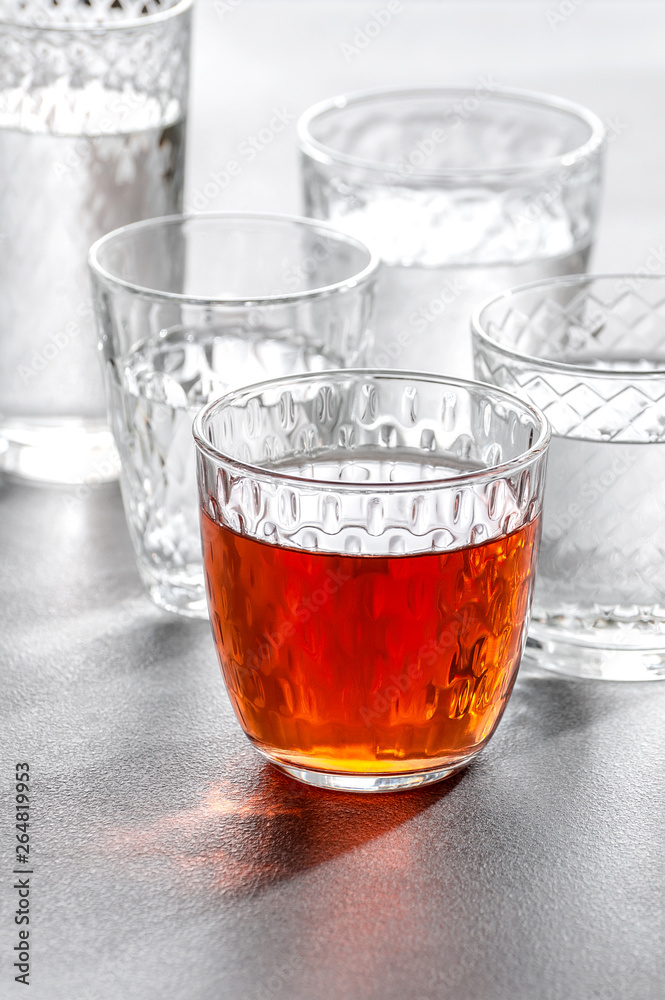 Glass glasses with water and drinks on a gray stone background.. Glass glasses with water and drinks on a gray stone background..