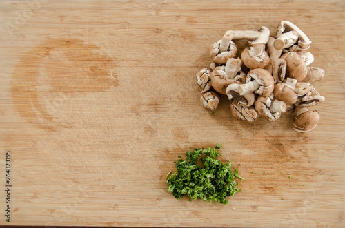 Parsley and mushroom on wooden table, cut and ready to be cooked. Top view in kitchen