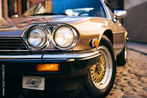 Close up of classic retro car turned on headlamp