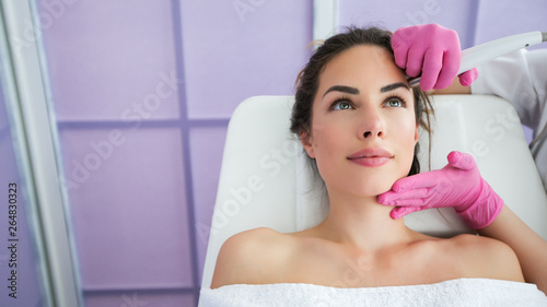 Beautiful woman in professional beauty salon during photo rejuvenation procedure