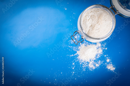Flour. A jar of wheat flour on a blue background.