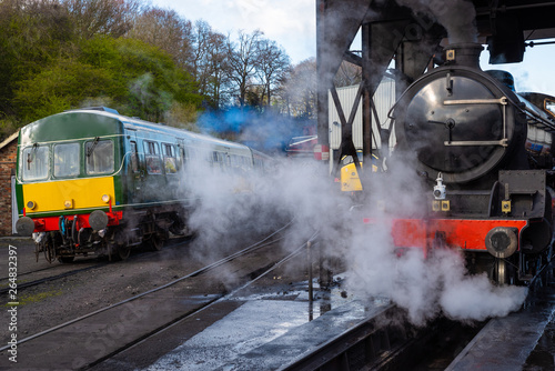 Steam and Diesel. Class B1 steam engine waiting under the coal hopper as a Class 101 Diesel Multiple Unit (DMU) leaves the station.