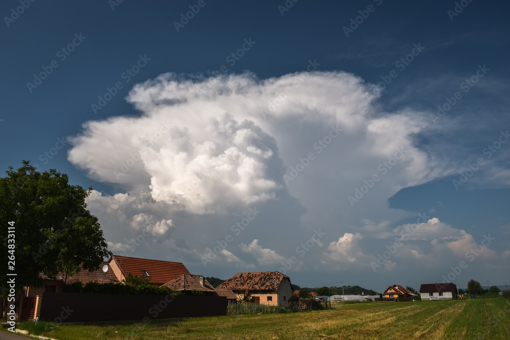 Classic example of a typical summer thunderstorm with updraft and anvil over the Carpathian mountains in Romania, eastern Europe.