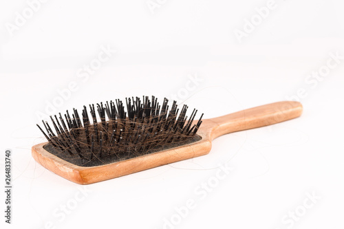 Comb with loose hair in it on a white table. closeup shot