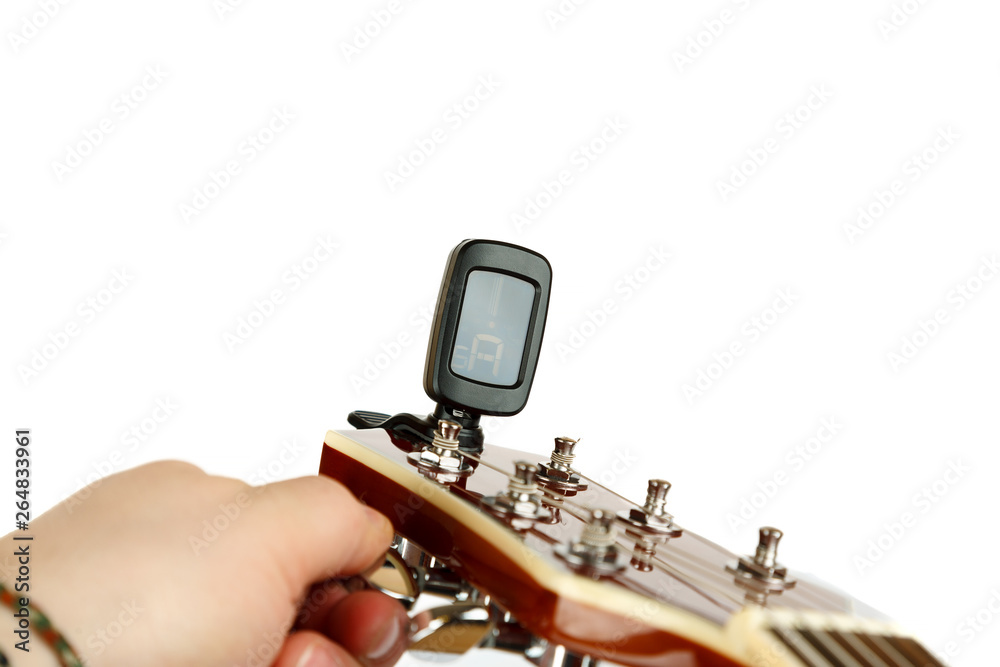 Hand tuning acoustic guitar with electronic tuner 스톡 사진 Adobe Stock