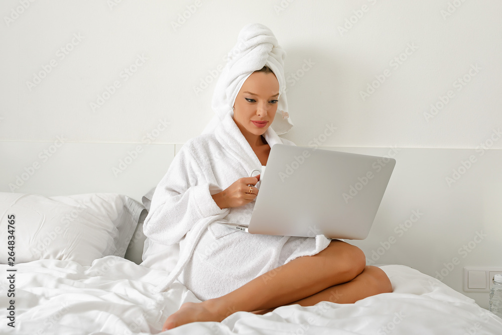 Waking up in a hotel, a young girl, a blogger, gladly does her job with a cup of freshly brewed coffee. Waking up in a hotel, a young girl, a blogger, gladly does her job with a cup of freshly brewed coffee.