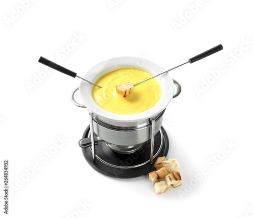 Fondue pot with melted cheese and bread on white background