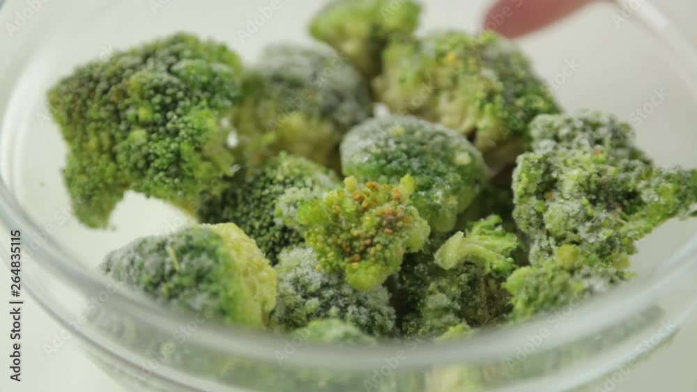 Preparation of fresh green cabbage. Frozen broccoli in a bowl.
