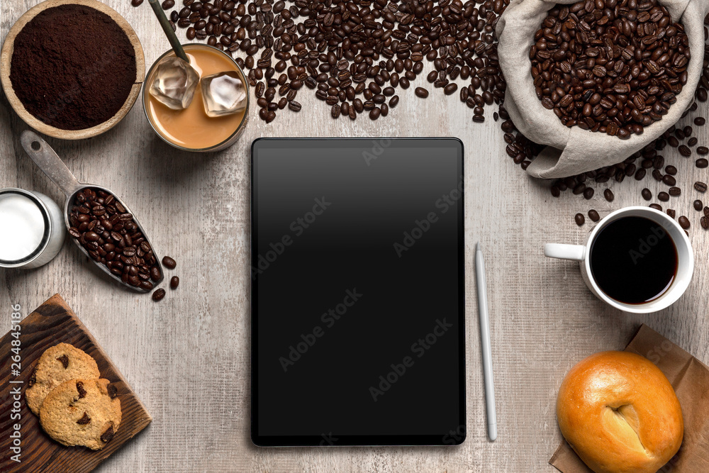 Above view of computer tablet with coffee shop ingredients in cafe, blank screen copy space Above view of computer tablet with coffee shop ingredients in cafe, blank screen copy space