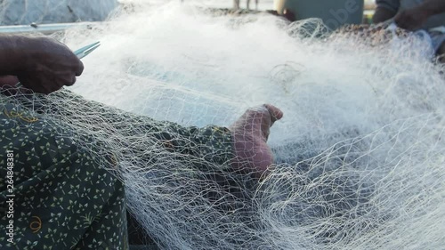 Fishermen repair their nets in front of the famed Chinese Nets in Fort Kochi, Kerala, India