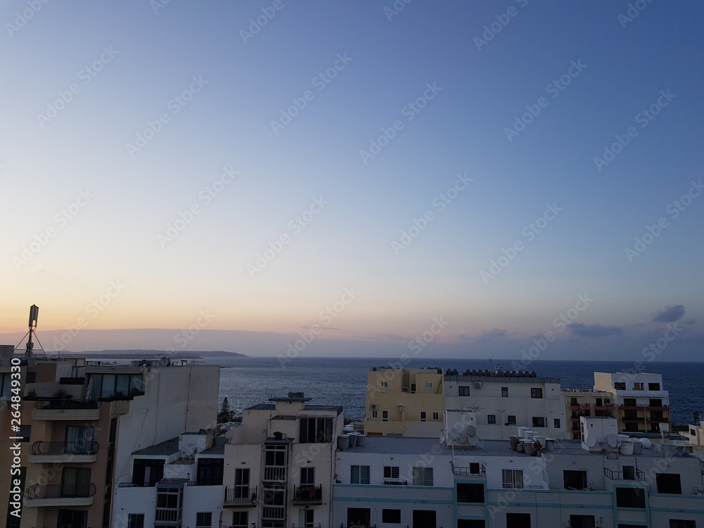Sunset over St. Paul's Bay buildings, Malta